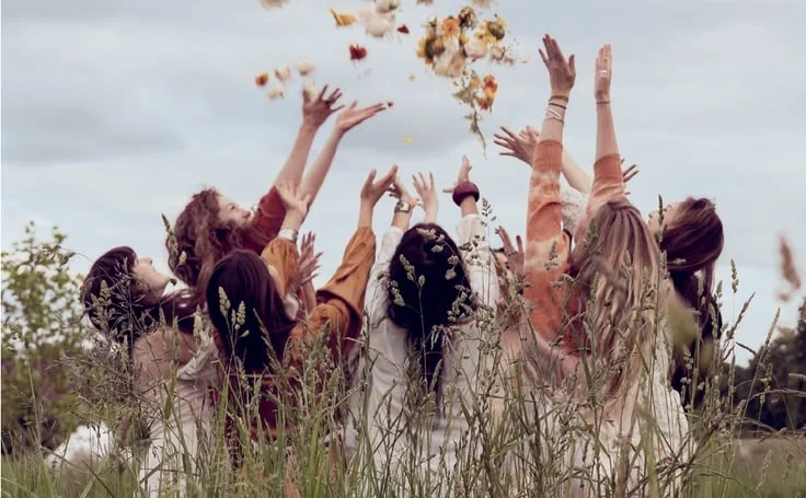 A group of women celebrating outdoors, illustrating group experiences and collaborations