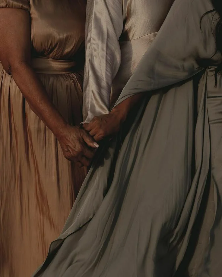 Women holding hands, illustrating community and mutual support
